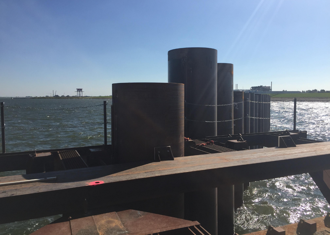 Röhrenförmige Königspfähle, die das Fundament einer Kaimauer bilden. Man sieht ihren ausgerichteten Einbau und die Abstände, die für das Ausfüllen der Lücken mit zahlreichen Spundwänden vorbereitet sind.