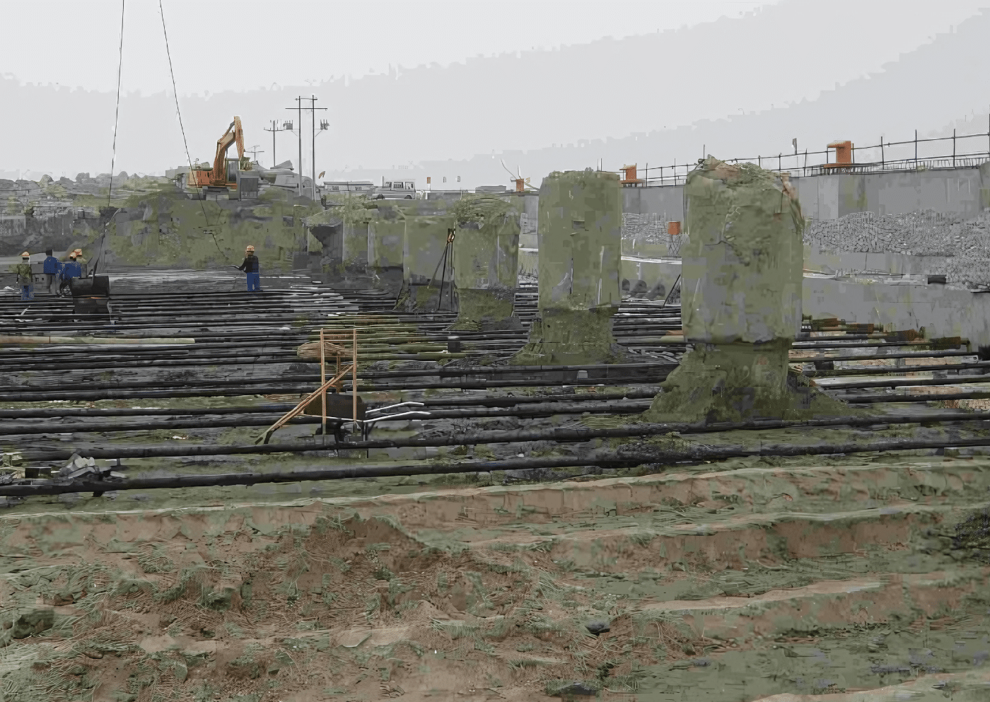Plac budowy na dużą skalę przedstawiający zakotwiczone pręty łączące połączone z zakopanymi blokami kotwiącymi