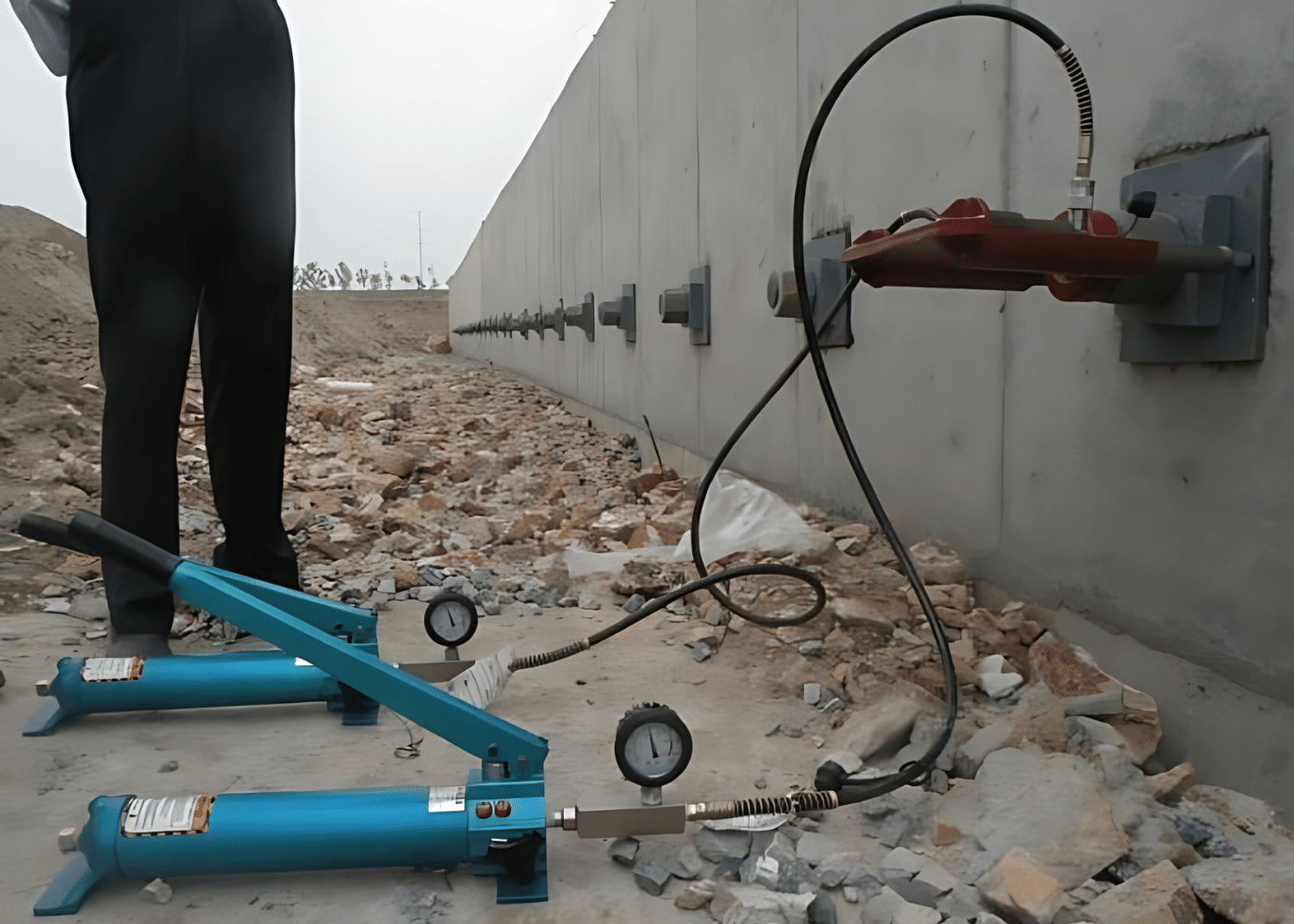 Hydrauliczny system podnośnikowy na miejscu do napinania zainstalowanych prętów kotwiących w betonowej ścianie kotwiącej